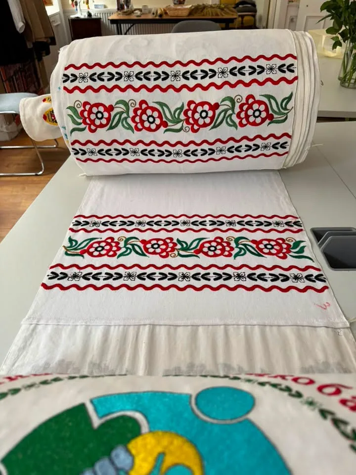 Red floral cross-stitch borders on a white runner.