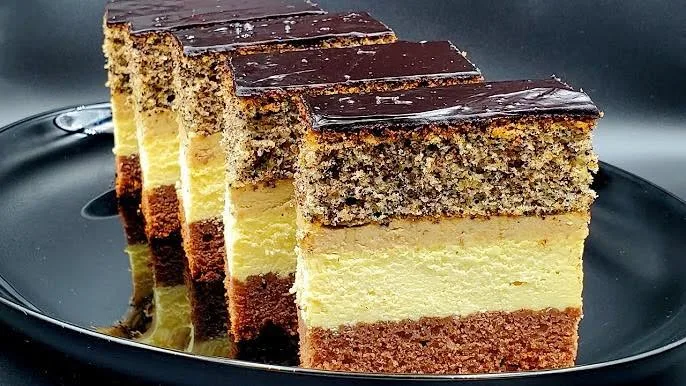 Slices of layered poppy-seed cake with dark chocolate topping.