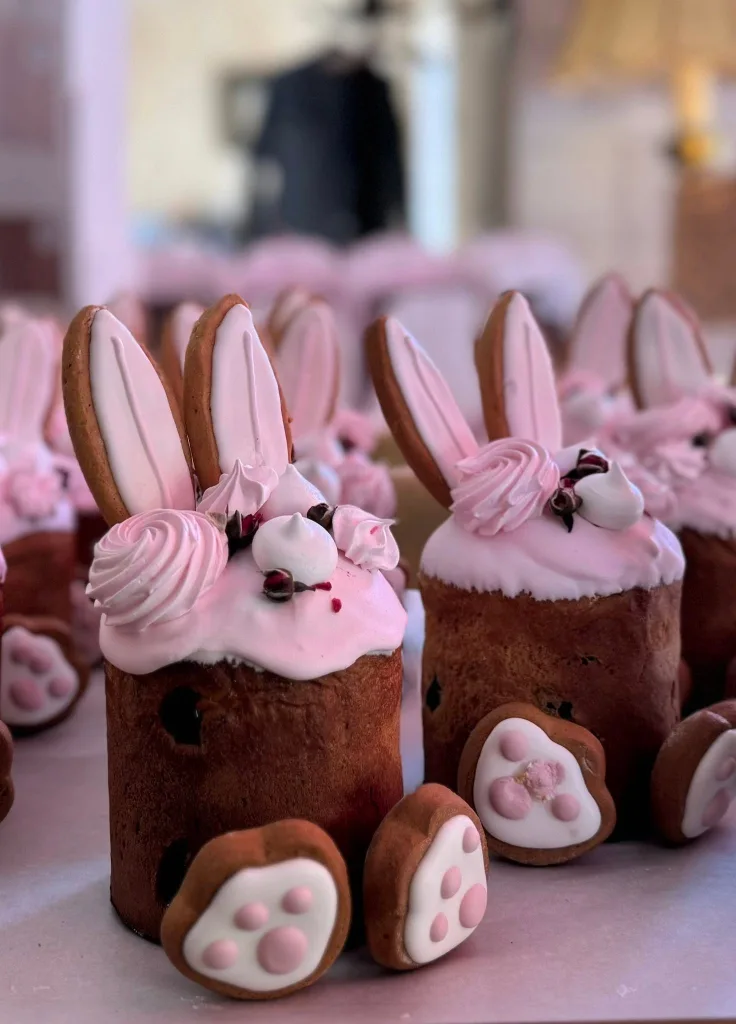 Easter breads iced in pink and decorated as rabbits, with ears and paws.