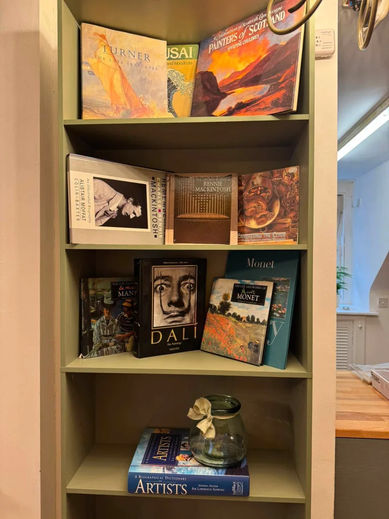 A shelf of art books, among them monographs on Dalí and Monet.