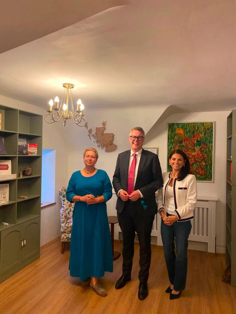 Three people standing together in the finished library room.