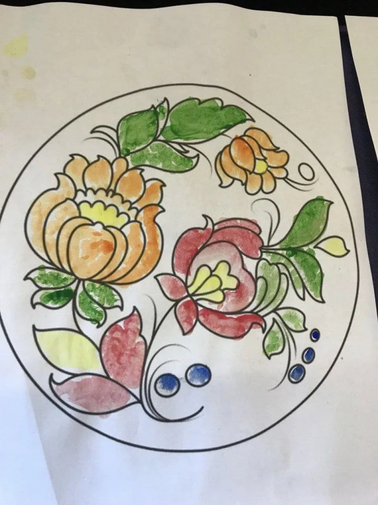 A Petrykivka floral design being painted in watercolour on paper