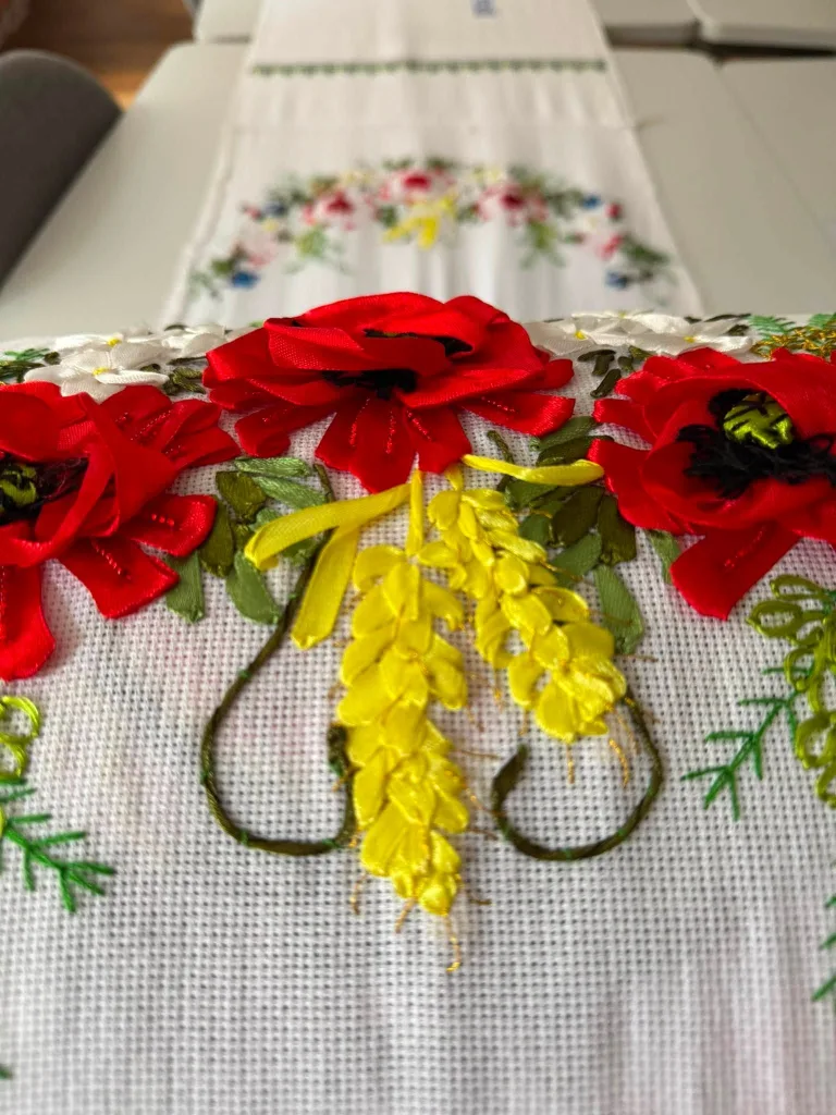 Poppies and yellow blossom embroidered on white linen
