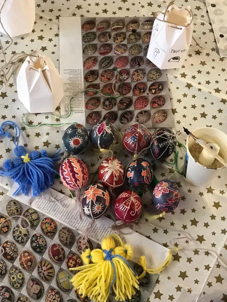 Finished pysanky laid out in rows with blue and yellow tassels.