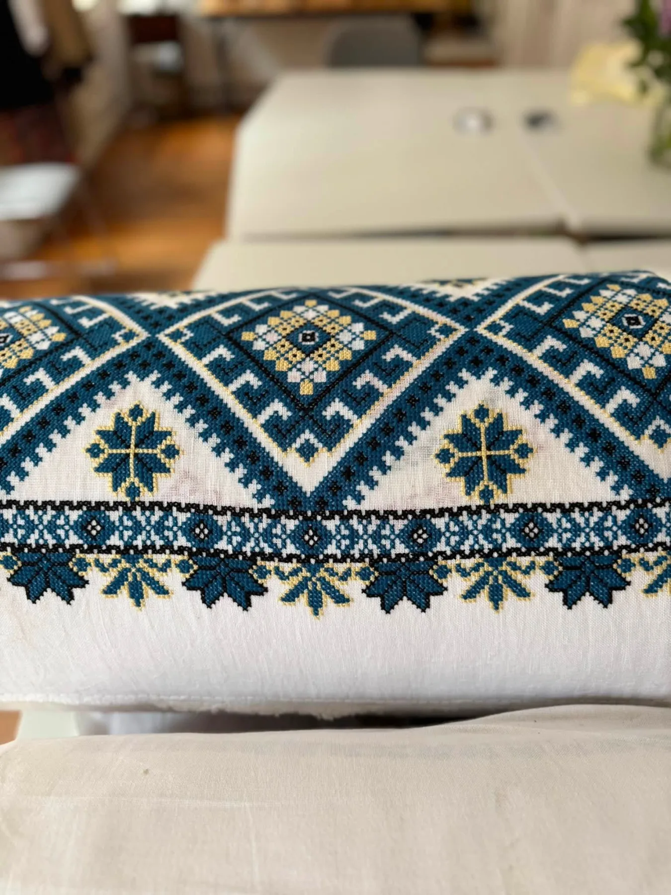 Blue and gold cross-stitch rushnyk folded on a table in Dutch Gable House